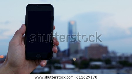 Hands Holding Cell Phone Mobile with City Landscape