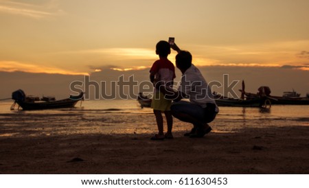 Blurry of happy family taking photo at beach  sunset background