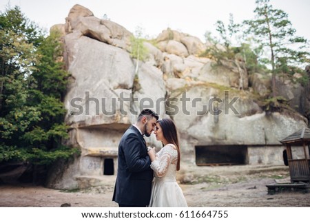 The lovely couple in love embarcing near stones