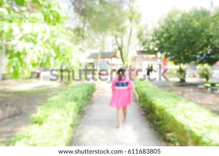 BLURRED BACKGROUND WOMAN WALKING IN PARK