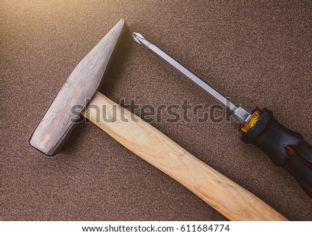 Hammer and screwdriver put on sandpaper. sun light