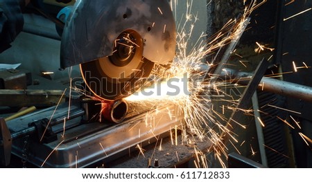 iron pipe cutting saw for metal with bright sparks Royalty-Free Stock Photo #611712833