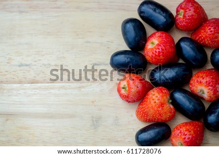 Fresh red strawberries and grapes on wood background for background,wallpaper,screensaver and copyspace,health food,vitamins fruits, beauty fruits,sweet and sour.