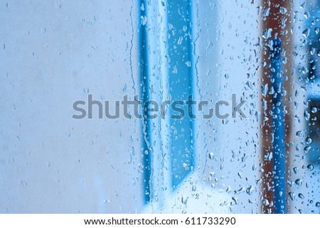 Window glass with increased condensation level, strong, high humidity in the room, large drops of water flow down the window, natural drops of water on the window glass, textures of water droplets 