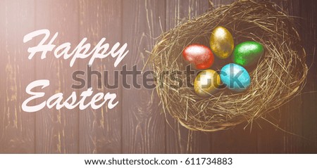 Happy Easter text, colored eggs in nest on rustic wooden planks. Top view, low light photography, panoramic photo