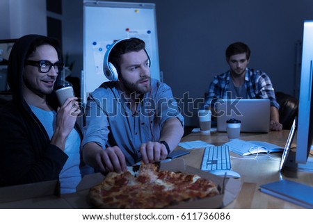 Pleasant positive programmer taking pizza slices