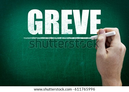 Hand writing the word GREVE on the blackboard ( Strike in Portuguese language )