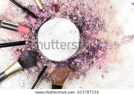 Makeup brushes, pencil, lipstick and other objects, forming a frame on a light background, with crushed powder and copy space. A horizontal template for a makeup artist's business card or flyer design
