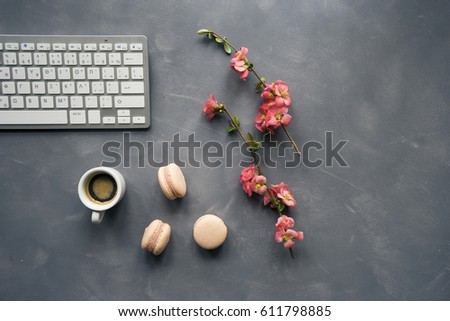 Office desk table with computer keyboard, cup of coffee and flowers