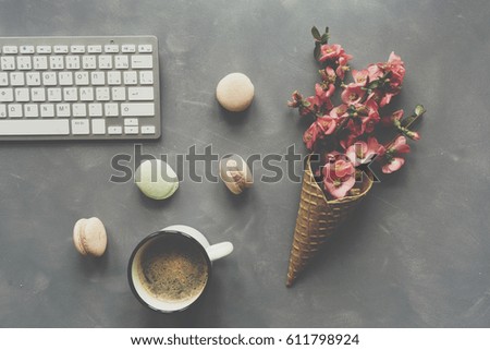 Office desk table with computer keyboard, cup of coffee and flowers