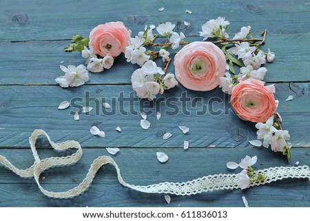 Ranunculus, sakura flowers , ribbon on wooden background 