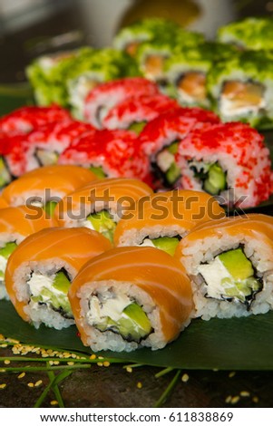 Various kind of sushi food served on black background. Sushi rolls served on a wooden plate in a restaurant