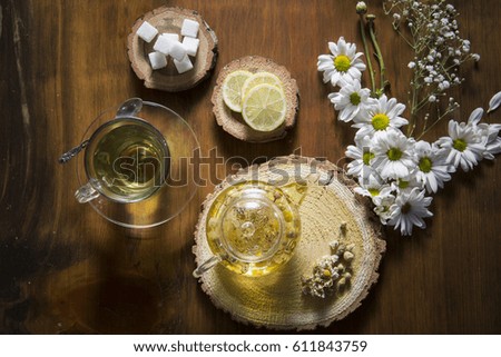 Food background with different black and green dry tea, rose buds cup of hot tea and iron teapot over dark wooden background. Tea drinking concept. Top view. Square image