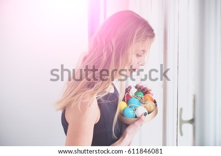colorful painted easter eggs in box, traditional spring holiday food. celebration and decoration. happy girl with long blonde hair and smiling cute face on white background.