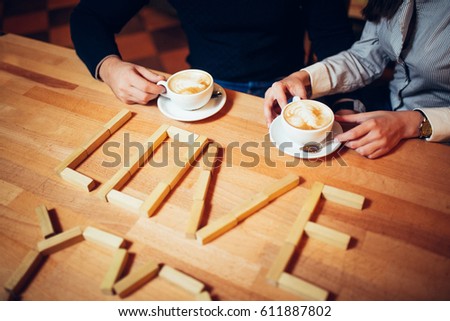 couple hands of coffee on a wooden table. inscription love on the table