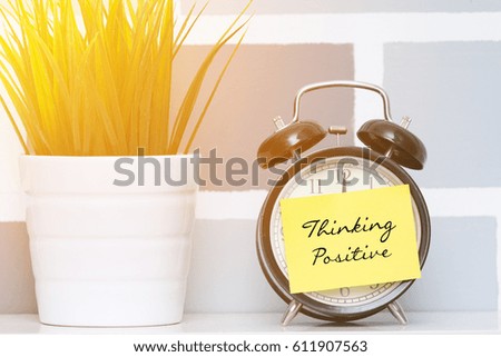 The concept of "Positive Thinking" on a sticky note on the clock
