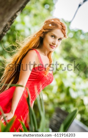 outdoor portrait of young happy smiling woman on natural tropical background
