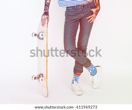 Woman standing and posing for picture with skateboard