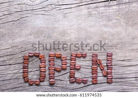 Word Open of coffee beans. Coffee beans on old wooden table