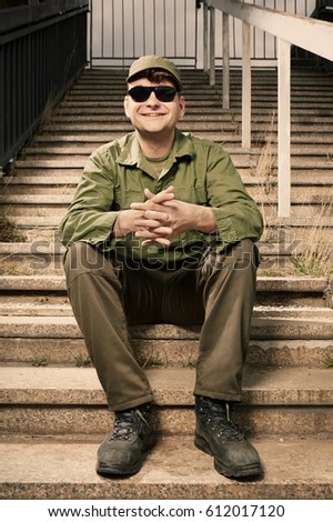 Soldier on sentry duty relaxing on stairs