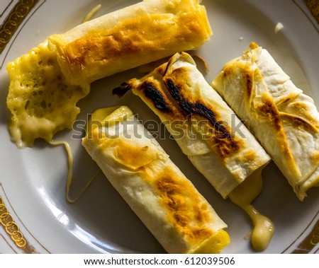 small round plate with four peaces of thin Armenian bread lavash fried in a pan with crispy crust. lavash sandwich with cheese folded in an envelope and fried. lavash with cheese as hot breakfast