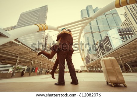 Happy moment of couple love, man in love lifting hi girlfriend in a hug,relaxing front of the urban background,concept about love,relationship, and travel couple concept