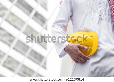 Arab Muslim engineer uniform and worker checking construction drawing at construction site. and space for your text