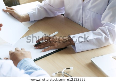 Two doctors discussing at desk in the hospital