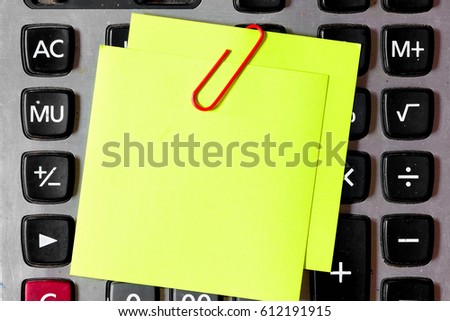 sticky note pasted on the calculator , Sticky notes and a calculator and paper statements - finance concept 