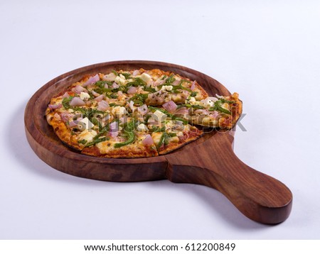 Paneer pizza served in a wooden plate on white background