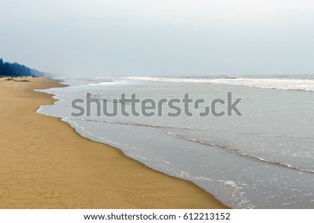 Lonely wild sand beach in Vietnam. Sea storm and cloudy sky