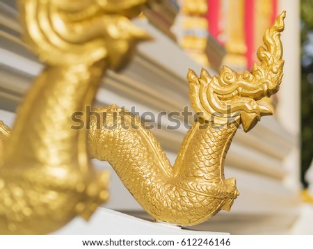 Naga statue adorn the stairway entry to chapel at thai temple.