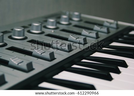 Midi keyboard close-up, keys and faders