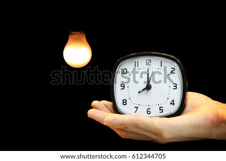 Man's hand holding Alarm clock,Lighting decor background