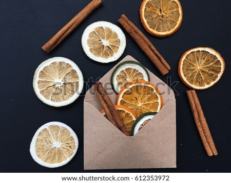 Concept dried fruits on black background in envelope. Cinnamon and dry fruits on chalkboard. 