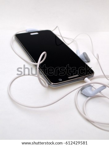 Photographing black phone with white headphones on a white background
