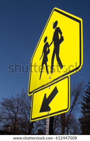 Bright yellow school crossing sign with arrow 