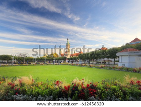 Beautiful resort town. Green lawn on chapel background. Green lawn under the blue sky on a summer day. Good resort background.