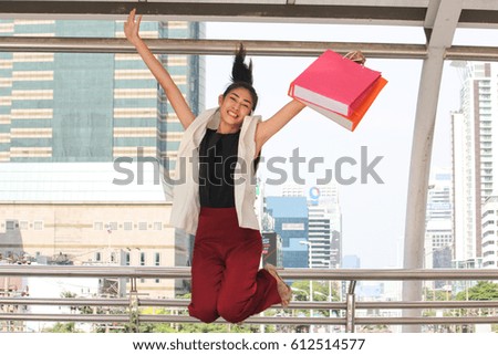 Happy young Asian woman shopping.
