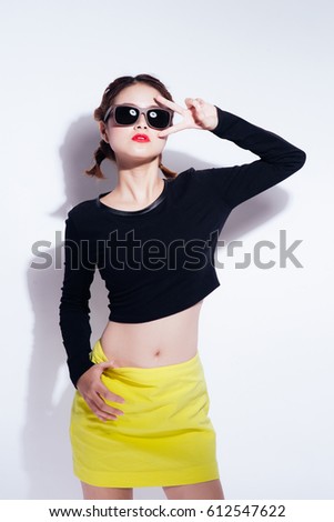 Young asian girl doing emotion. Dressed in a black shirt and yellow skirt, glasses and bright lips,trendy clothes. Warm color. White background, not isolated