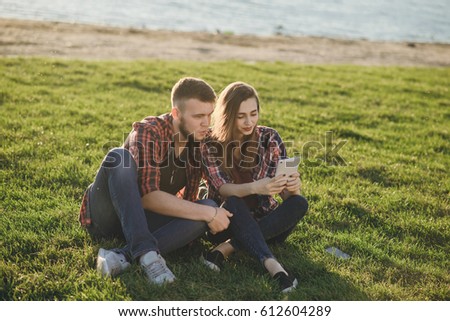 couple walks the park and the river. resting on the beach. uses communication