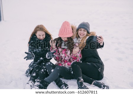 three girls sittin on the frozen river