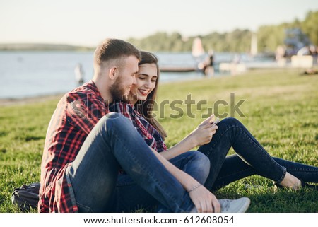 couple walks the park and the river. resting on the beach. uses communication