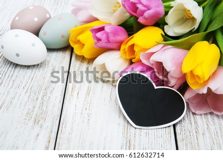 Easter eggs and tulips  on a old wooden table