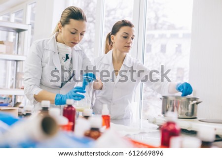 Small business people at work. Two young womens are working at their laboratory of cosmetic production. 