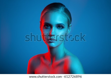 Fashion art portrait of beautiful woman face. Red and blue light color.