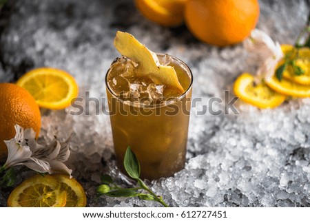 Cocktails in a glass, orange, ginger and rosemary on ice against a dark background. A drink of fresh lemonade close-up.
