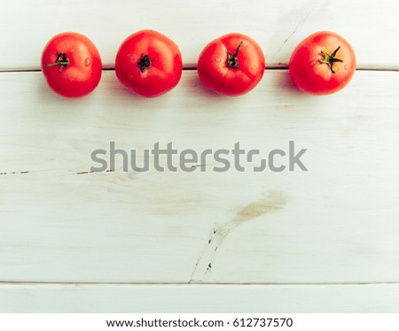 Group of fresh healthy tomatoes on a white wooden background.  Additional place for text.