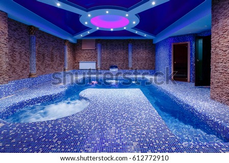Pool with illumination and waterfall, entrance to the sauna, the concept of hardening of health, walrus. Illuminations.