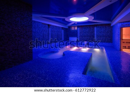 Pool with illumination and waterfall, dark background, entrance to the sauna, concept of hardening of health, walrus. Light in the jacuzzi.